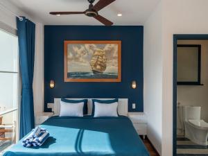 a blue bedroom with a bed with a blue wall at Shadyside 4B in Tân Thành (1) +32 photos