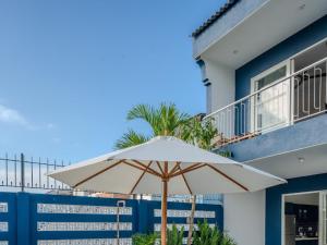 a white umbrella sitting in front of a building at Shadyside 4B in Tân Thành (1)