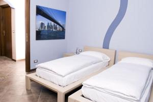 duas camas num quarto com uma fotografia na parede em Residence Corona Grossa em Ciriè