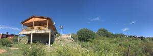 a building on the side of a hill at Cabaña Flor Serrana in Tanti