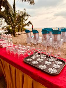 a table with wine glasses on the beach at Taya Beach Front in Gokarna