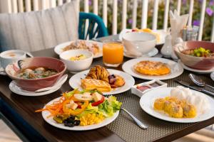 a table topped with plates of food and drinks at Away Bangkok Riverside Kene in Bangkok +95 photos