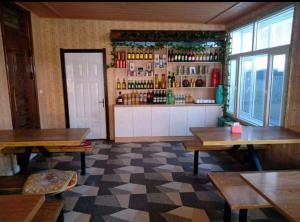 a restaurant with tables and a bar with bottles at Snow Valley Xishui Dragon Soaring Inn in Wuchang