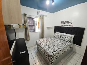 a small bedroom with a bed and a window at Apt Graphos Turu - 2 Ar, piscina, completo in São Luís