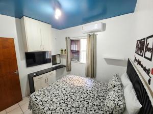 a small room with a bed and a television at Apt Graphos Turu - 2 Ar, piscina, completo in São Luís