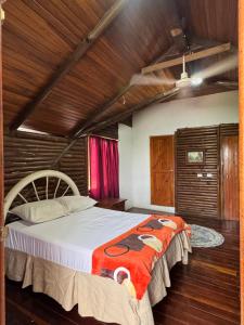 a bedroom with a large bed in a room with wooden ceilings at Cabaña Brisa Del Río in Cooper