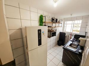 a kitchen with a white refrigerator in a room at Apt Graphos Turu - 2 Ar, piscina, completo in São Luís +14 photos