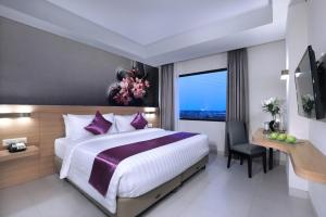 a bedroom with a bed and a desk and a window at Quest Prime Cikarang by ASTON in Bekasi +23 photos