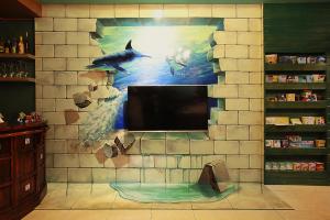 uma parede com um mural de um tubarão e uma televisão em 3D Sunflower Embossed B&B em Hualien City