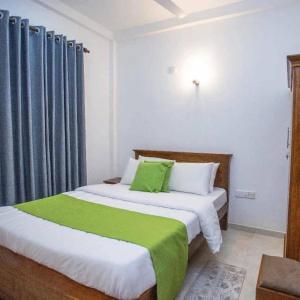 a bedroom with two beds with green sheets at Sahan geust inn in Wellawaya