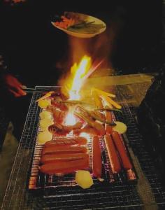 a grill with a bunch of hot dogs and bacon at Sahan geust inn in Wellawaya