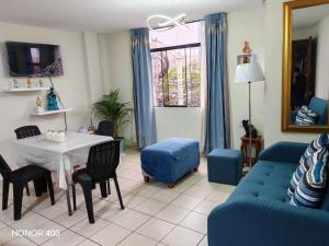 a living room with a table and a blue couch at Adel 2 Ovalo Larco Departamento in Trujillo