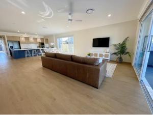 a large living room with a couch and a kitchen at Capri Waterfront Resort-Style 5BR & Pool in Gold Coast