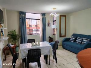 a living room with a table and a blue couch at Adel 2 Ovalo Larco Departamento in Trujillo