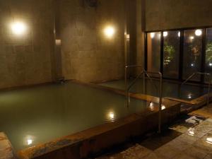 an empty pool of water in a building at night at Hotel Kadoman in Aso