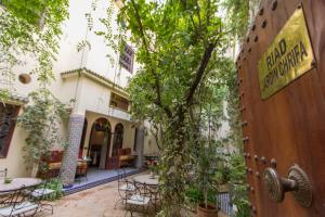 a courtyard with tables and chairs and a tree at Riad Jardin Chrifa in Fez