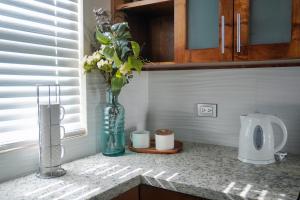 a kitchen counter with a vase with flowers in it at Beach, Please MX in Puerto Peñasco