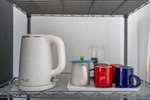 a shelf with cups and a coffee maker on a counter at The Twenty Eight in Ungasan