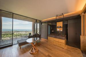 a living room with a table and a large window at SEKIYA RESORT Galleria Midobaru in Beppu