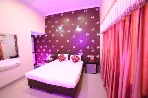 a bedroom with a large bed with purple walls and red curtains at Kangs Nirvana Resorts and Spa in Hoshiārpur