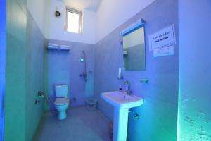 a blue bathroom with a toilet and a sink at Kangs Nirvana Resorts and Spa in Hoshiārpur +12 photos
