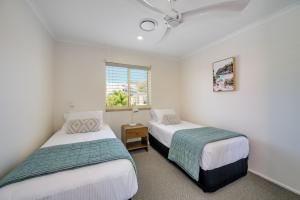 a bedroom with two beds and a window at #2 Hastings Street in Noosa Heads