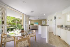 a kitchen and living room with a table and chairs at #2 Hastings Street in Noosa Heads