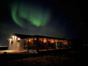 a house with the aurora in the sky at Cozy and Modern Cabins in Selfoss in Selfoss