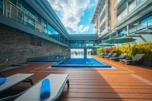 a large building with a swimming pool in a courtyard at Palm Springs Hotel Dili in Dili