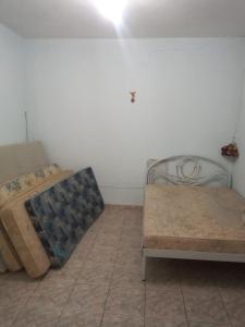 a bedroom with two beds and a tiled floor at Chácara Seu Antônio in Mombuca