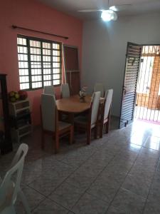 a dining room with a wooden table and chairs at Chácara Seu Antônio in Mombuca