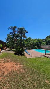 an empty swimming pool with a fence in the grass at Chácara Seu Antônio in Mombuca