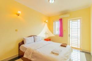 a bedroom with a large bed with yellow walls at Serey Sok San Apartment in Phumi Ta Phul