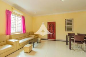 a living room with a couch and a table at Serey Sok San Apartment in Phumi Ta Phul