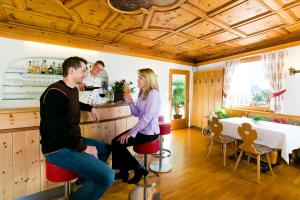 grupa ludzi siedzących w barze w pokoju w obiekcie Hotel Öhlerhof w mieście Lagundo