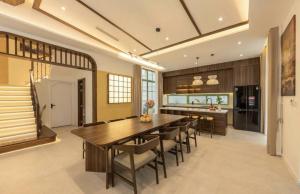 a kitchen with a large wooden table and chairs at Hana Village Garden Tropical Bãi Khem in Phú Quốc