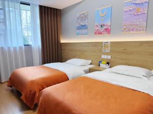 a hotel room with two beds and a window at 恩宜客栈 in Dujiangyan