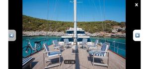 a boat with chairs on a dock in the water at Meridian bleu in Salamina