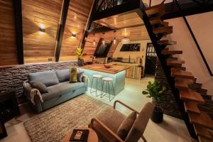 a living room with a couch and a kitchen at Luxury AFrame with Private Jacuzzi Poás Volcano in Vara Blanca