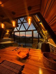 a wooden table in a room with a large window at Luxury AFrame with Private Jacuzzi Poás Volcano in Vara Blanca