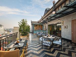 a patio with tables and chairs on a balcony at HOTEL du LAC SIGNATURE in Hanoi