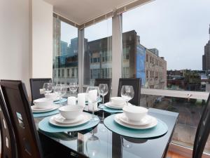 a dining room with a table with plates and wine glasses at Fantastic Philly Fully Furnished Apartments in Philadelphia