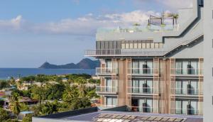 an apartment building with a balcony and a view of the ocean at Palm Springs Hotel Dili in Dili