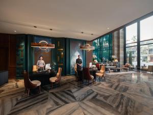 a lobby of a hotel with two men standing at tables at HOTEL du LAC SIGNATURE in Hanoi +151 photos