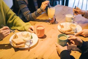 a group of people sitting around a table eating food at Imano Tokyo Hostel in Tokyo