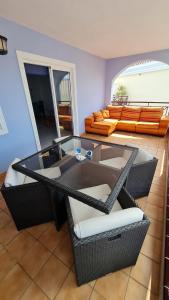 a living room with a glass table and wicker chairs at a SPECIAL place in Los Cristianos