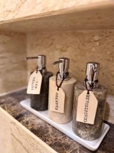 three bottles of soap sitting on a shelf at Baan Yanikar in Lampang