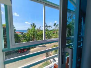 an open window with a view of a beach at Bougainvillea guesthouse in San Juan
