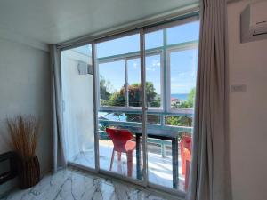 a room with a large window with a red chair at Bougainvillea guesthouse in San Juan