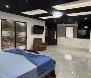 a bedroom with a bed and a tv and a chair at Brisa marina in Moín